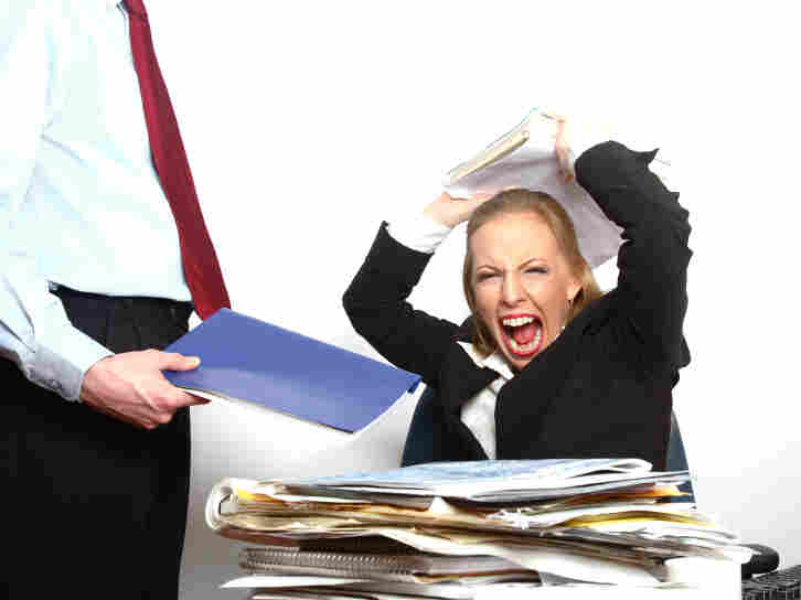 Angry woman at desk.