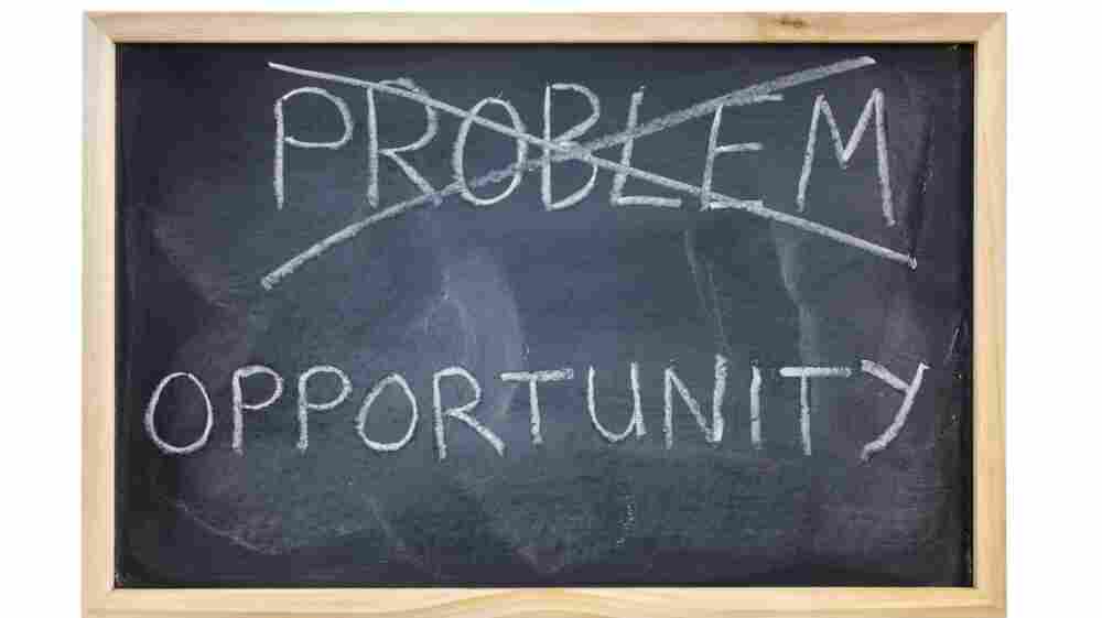 The word "problem" is crossed out on a blackboard and replaced with the word opportunity.