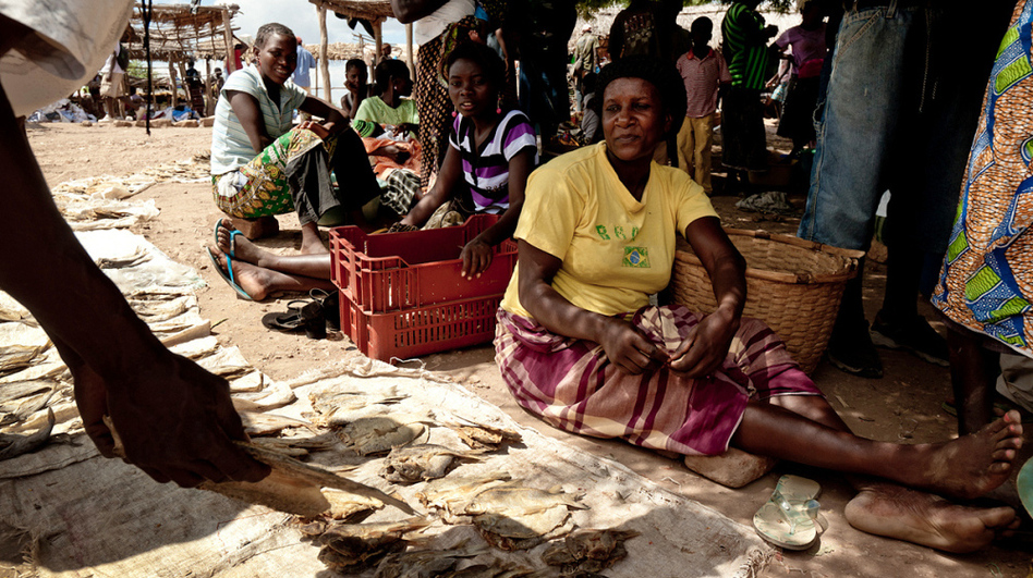 Lidia dos Santos sells fish at a market near the village of Marara. Dos Santos, who is HIV positive, helps to oversee local patient groups and says the experience has made her consider becoming a nurse. (Vlad Sokhin for NPR)