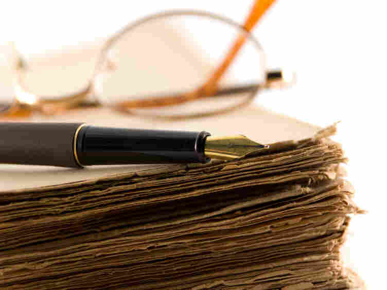 Glasses and a pen rest on a manuscript.