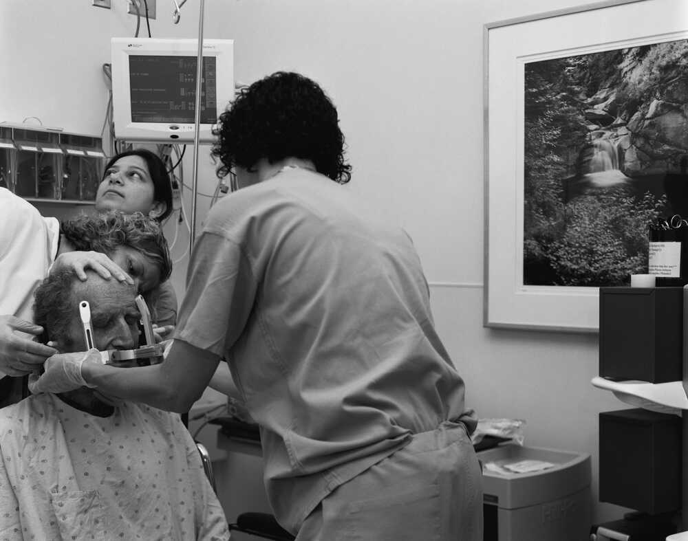 Nurses prepare Bob Hardman for surgery by securing his head in a metal halo.
