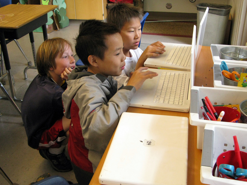 Fifth-graders (from left) Reese Toomre, Lucas Nguyen and Michael An race through the Khan Academy's Trigonometry Challenge. The program allows more advanced students to move ahead, while other students can proceed at their own pace. (Larry Abramson/NPR)