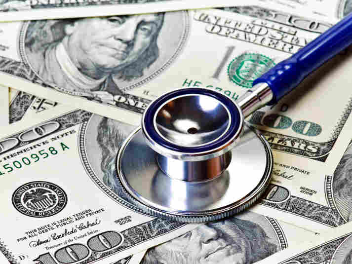 Stethoscope rests on $100 bills.