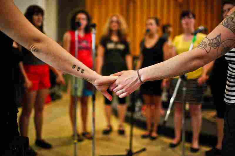 Singers from the Assembly of Light Choir hold hands as they prepare for their performance later that evening.