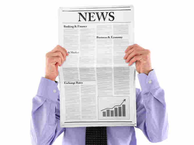 Man hidden behind newspaper.