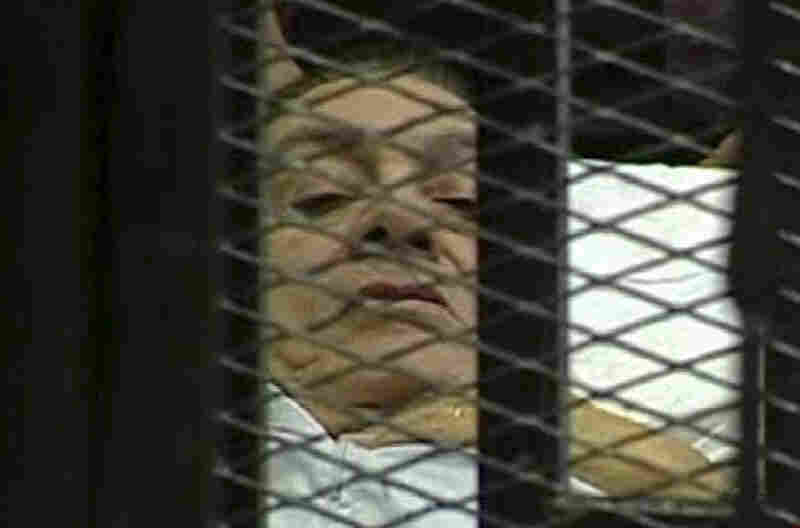 Former Egyptian President Hosni Mubarak lies on a hospital bed inside a bars-and-mesh defendant's cage in a Cairo courtroom as he went on trial Wednesday on charges of corruption and ordering the killing of protesters. Although such cages aren't unusual in many countries, the televised images of Mubarak shocked people in Egypt and around the globe. 