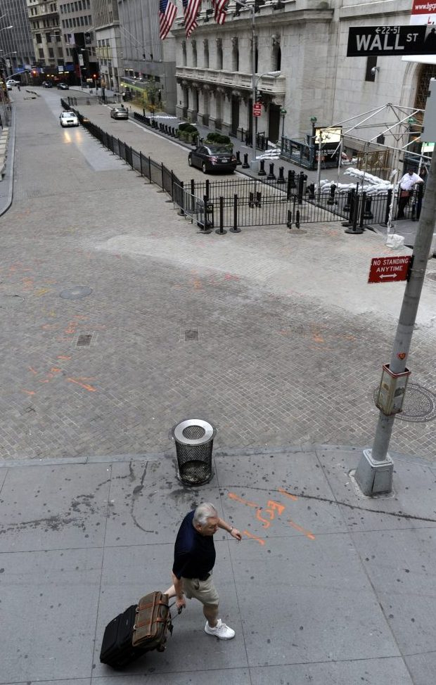 Earlier today, a man pulled his luggage up Wall Street — one of the low-lying areas — in Manhattan. (AFP/Getty Images)