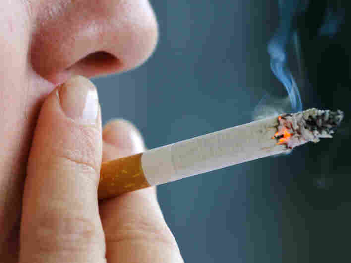 A woman puffs on a cigarette.