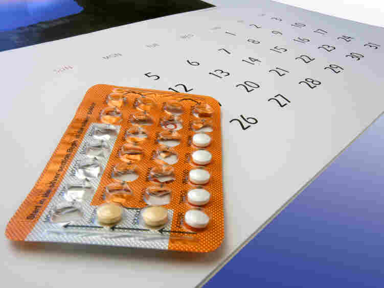 Birth control pills on a calendar.