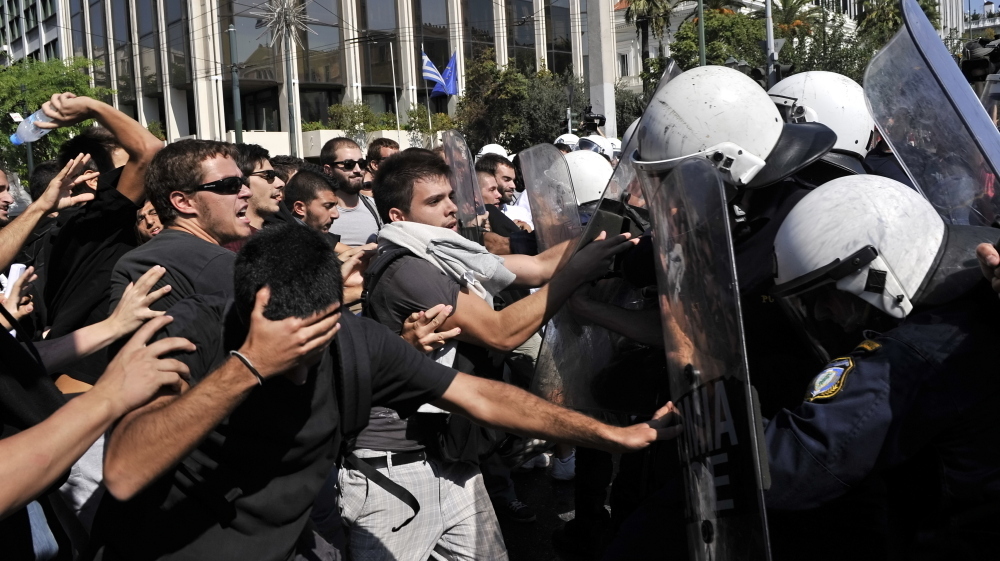 <p>High school students protesting austerity measures clash with riot police in front of the Greek Parliament on Monday. Also Monday, the Greek government announced that it would not meet its targets for reducing the budget deficit.</p> (AFP/Getty Images)