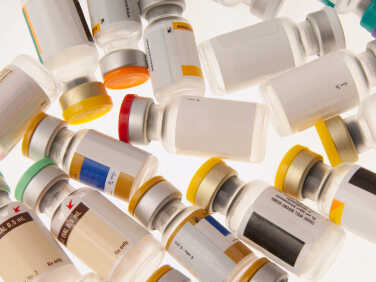Vials of different vaccines with color-coded caps.
