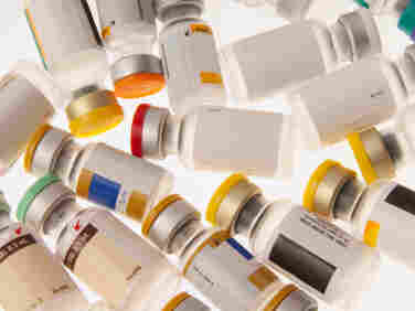 Vials of different vaccines with color-coded caps.