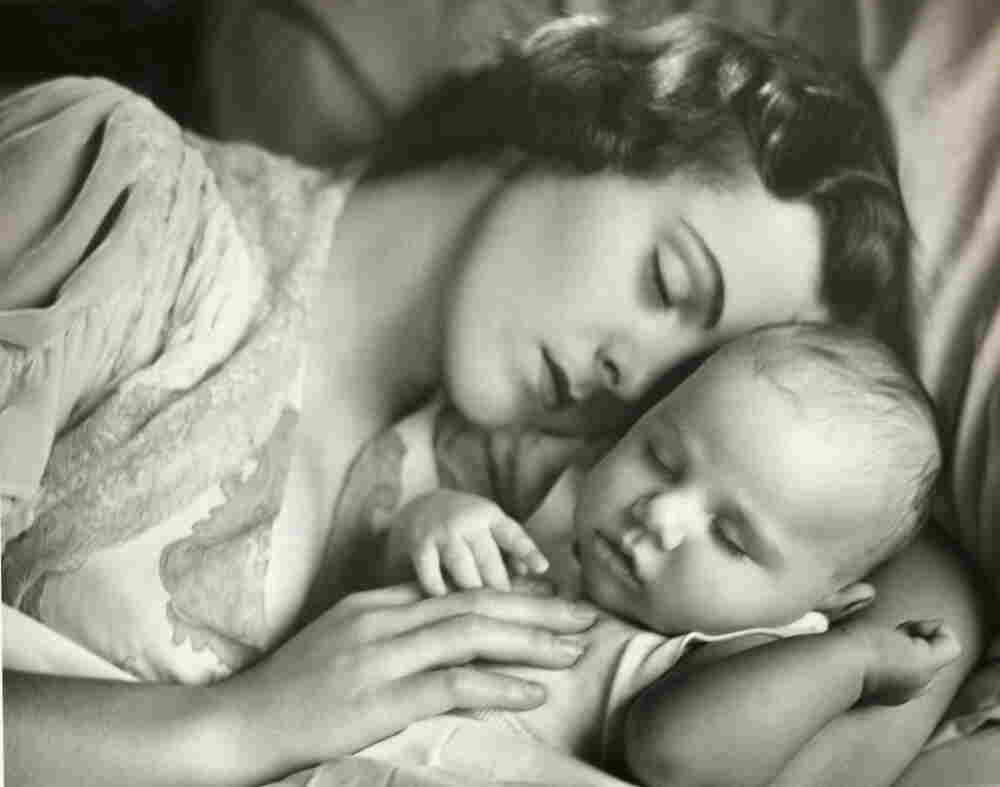 A 1950s photo of a mother and child sleeping in bed.