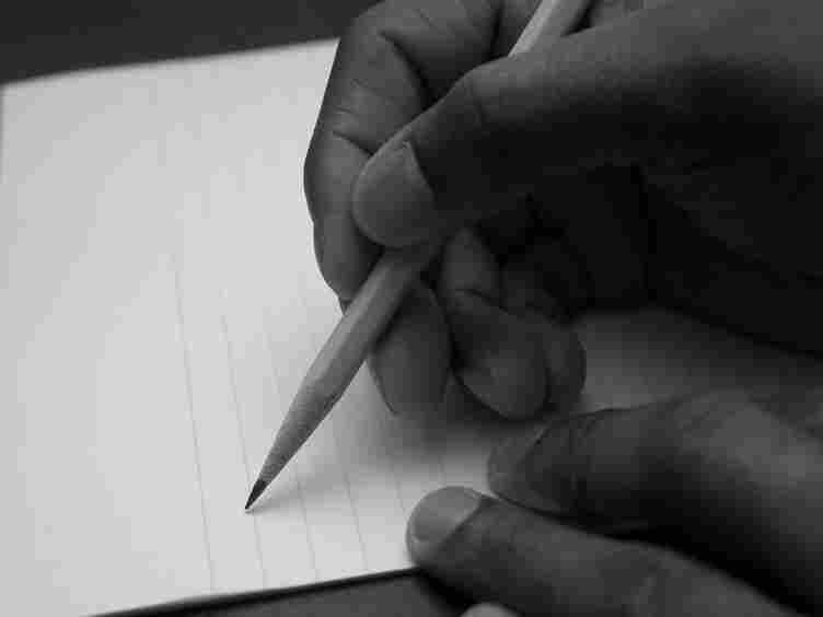 A hand taking a pencil to paper.