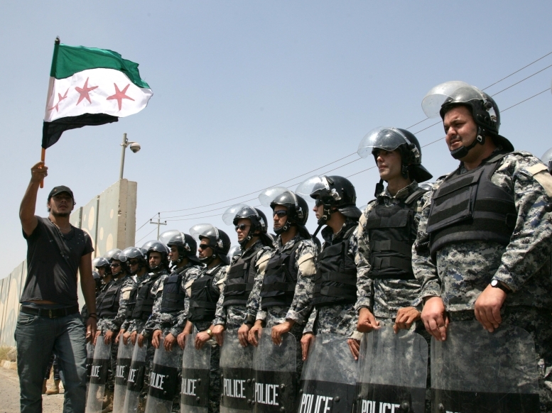 Riot police stand guard as Syrian Kurds protest in front of the UN office in the northern Iraqi Kurdish city of Arbil, to demand the departure of the Syrian President Bashar al-Assad's regime, on June 27, 2011. (AFP/Getty Images)