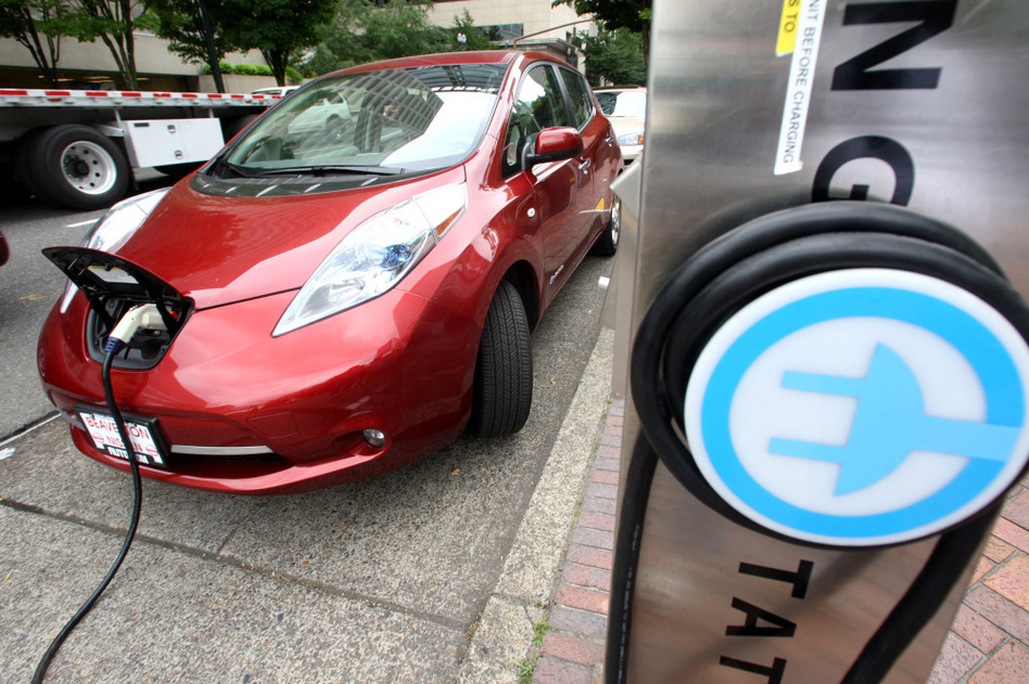 A Nissan Leaf charges at a station in Portland, Ore., that can recharge an electric car in 30 minutes. Electric cars could be an integral part of meeting 55-mpg fuel standards by 2025, but many consumers are put off by the vehicles' higher price and what some call "range anxiety." (Rick Bowmer/AP)