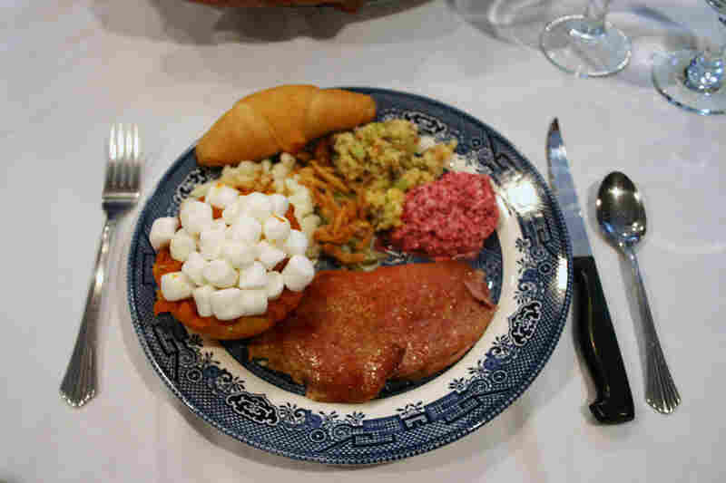 The pink star of the meal—aside from the turkey, of course—shares a plate with mashed sweet potatoes, stuffing and green bean casserole.
