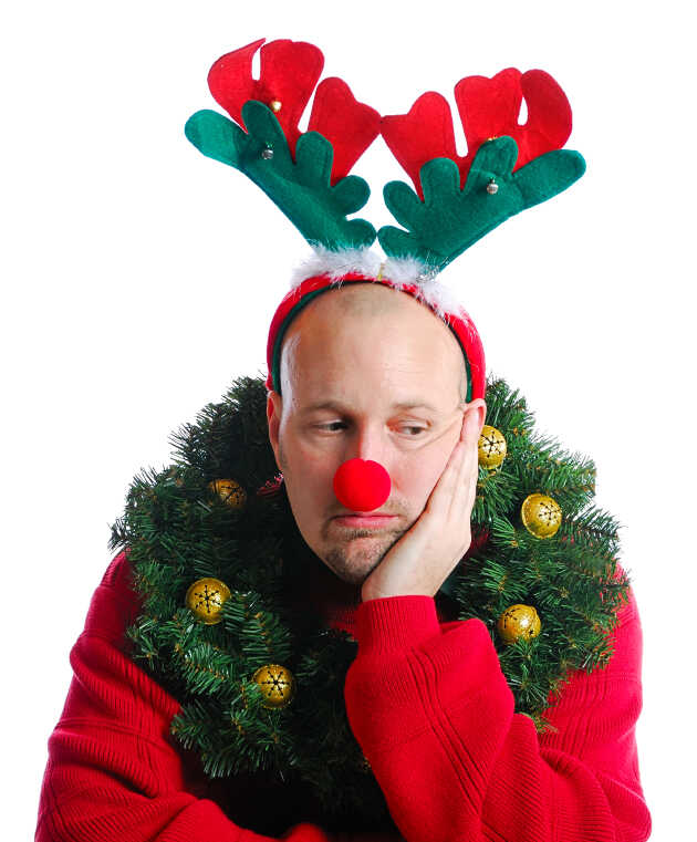 A man bedecked in Christmas attire and looking miserable.