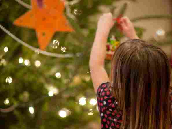 A child decorates a Christmas tree