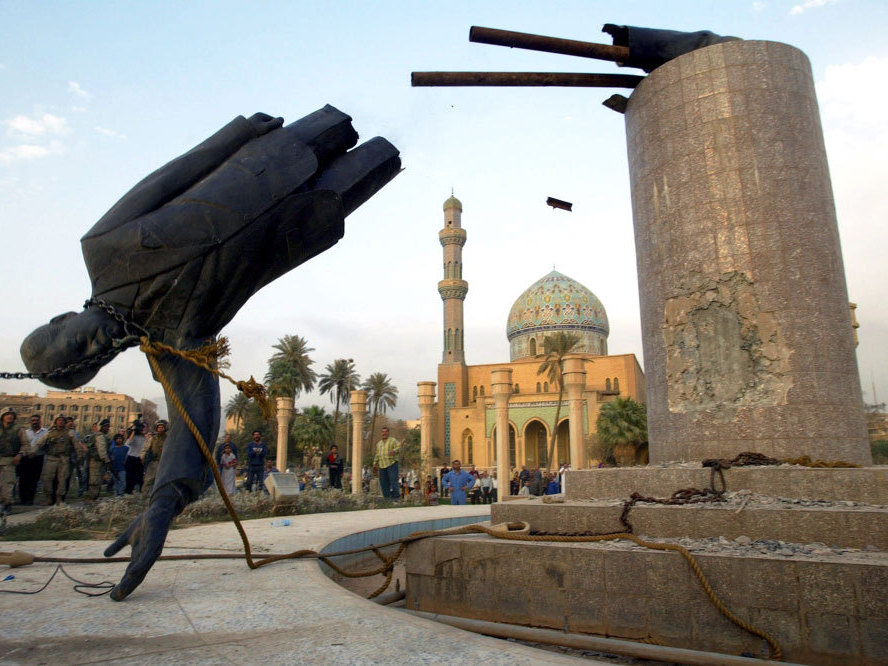 U.S. troops topple a statue of Saddam Hussein on April 9, 2003, the 21st day of Operation Iraqi Freedom, in central Baghdad. (Getty Images)