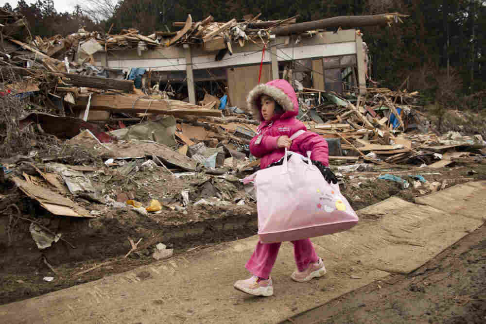 Neena Sasaki, 5, carries some of the family belongings from her home that was destroyed after the earthquake and tsunami in Rikuzentakata, Miyagi province, Japan, March 15.