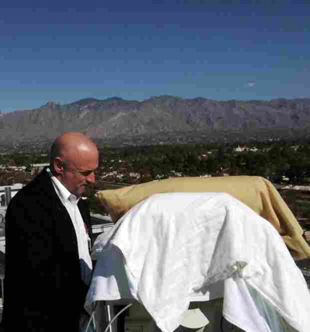 Kelly stands over his wife's hospital bed on a deck outside University Medical Center on Jan. 20. 