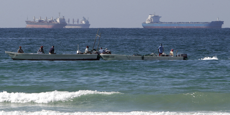Fishing boats are seen in front of oil tankers on the Persian Gulf waters, south of the Strait of Hormuz. The European Union has announced plans to join U.S. efforts to slow the flow of oil from Iran, the world's third largest exporter. (Kamran Jebreili/AP)