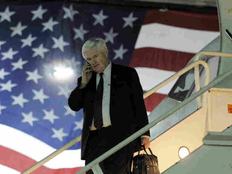 GOP presidential candidate Newt Gingrich speaks on a mobile phone as he arrives on a charter plane on Jan. 27 in Miami, Fla.