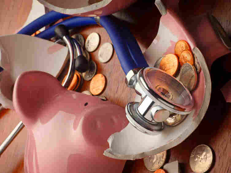 A stethoscope rests on a broken piggy bank.