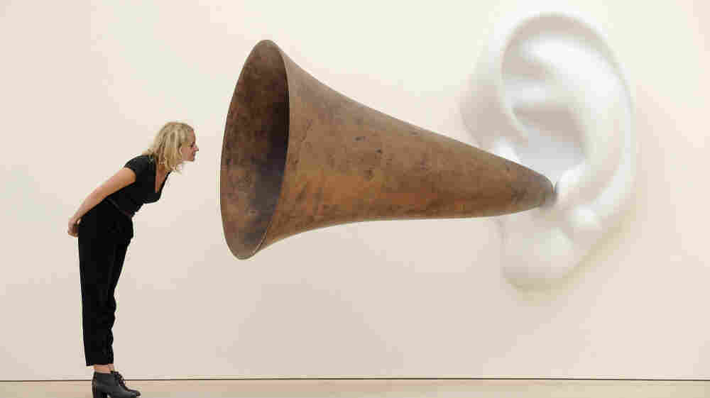 An employee poses next to an installation by US artist John Baldessari entitled 'Beethoven's Trumpet (With Ear)' at the Saatchi Gallery in central London on May 26, 2011.