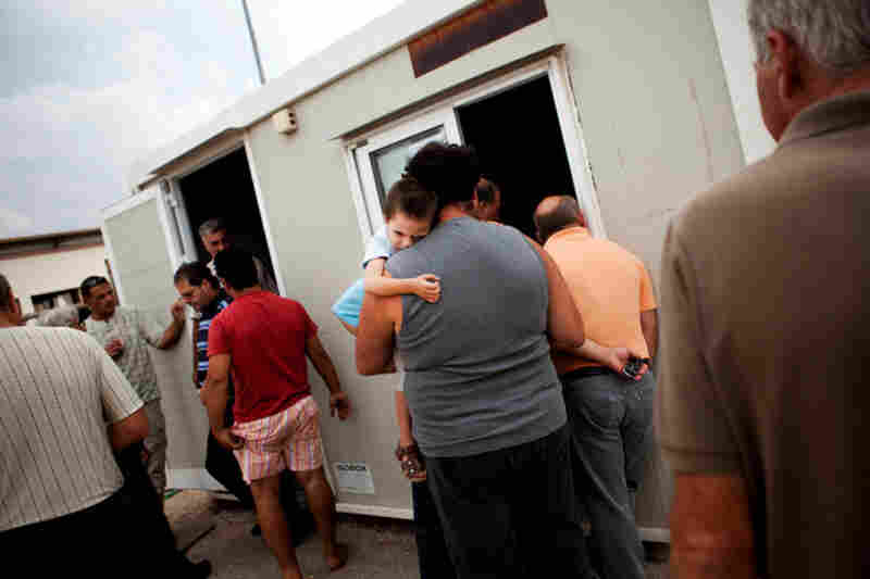 Dock workers stand in line outside union offices in Perama to be called for work. Some say they have worked only a couple months in the past two years.