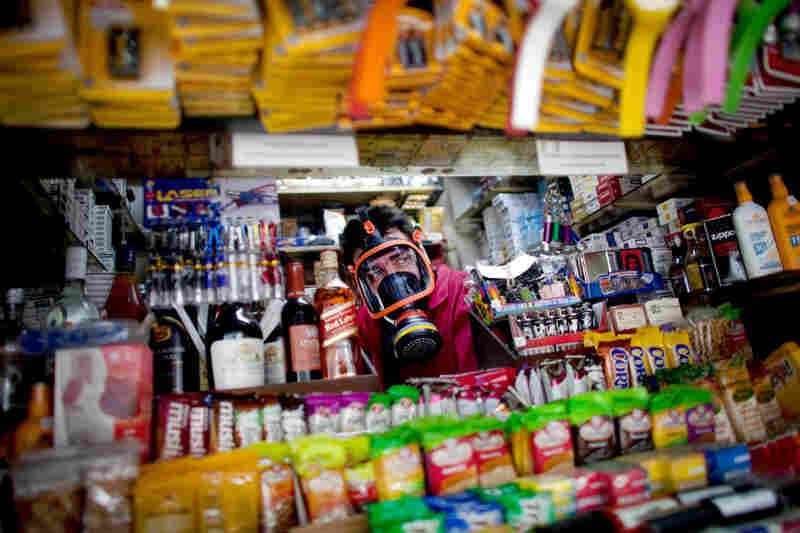 A kiosk owner wears a gas mask during anti-austerity protests outside parliament in Athens last June.