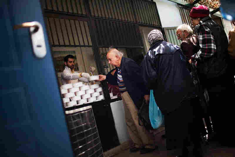 People line up for food at the Athenian Municipal Solidarity Center, which provides three daily meals for the homeless. The face of homelessness has changed in Greece, as white-collar workers have increasingly lost their jobs and require psychological support, food and shelter.