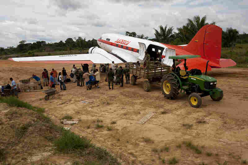 Passengers and military troops prepare to board a DC-3.