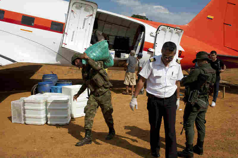Co-pilot Victor Valencia walks away from his DC-3 with Colombian soldiers.