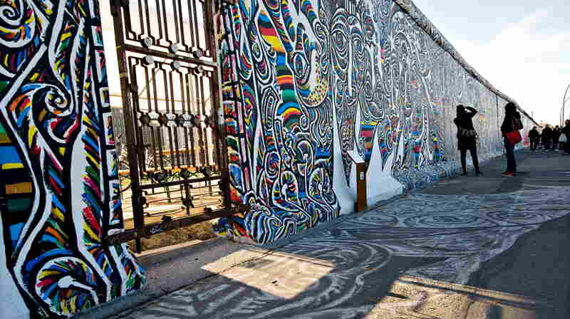 Tourists take photographs of the murals painted onto the section of the Berlin Wall known as the "East Side Gallery" in central Berlin, on Nov. 7, 2009.