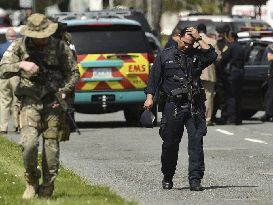 An Oakland police officer walks outside of Oikos University in Oakland, Calif., Monday. (Noah Berger/AP)