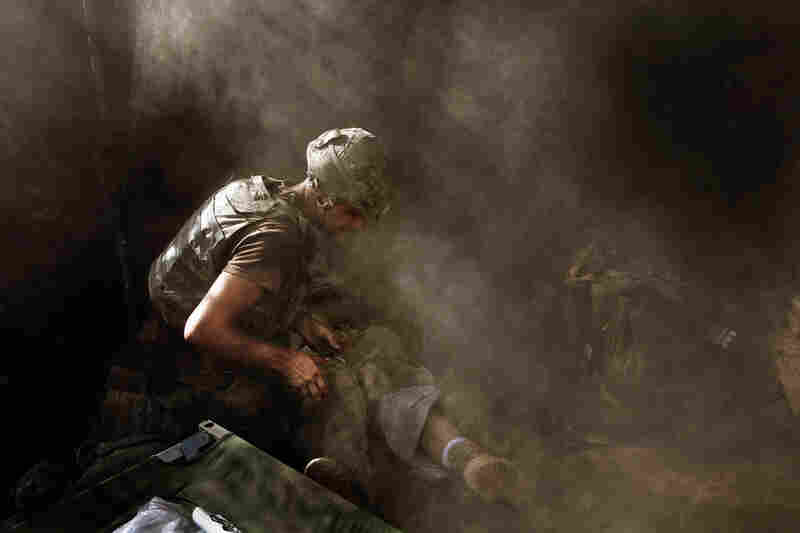 2007: Medic David "Doc" Old treats Spc. Miguel Gutierrez of the 2nd Platoon, who was injured during an attack by Taliban fighters on the Restrepo outpost in Afghanistan's Korengal Valley.