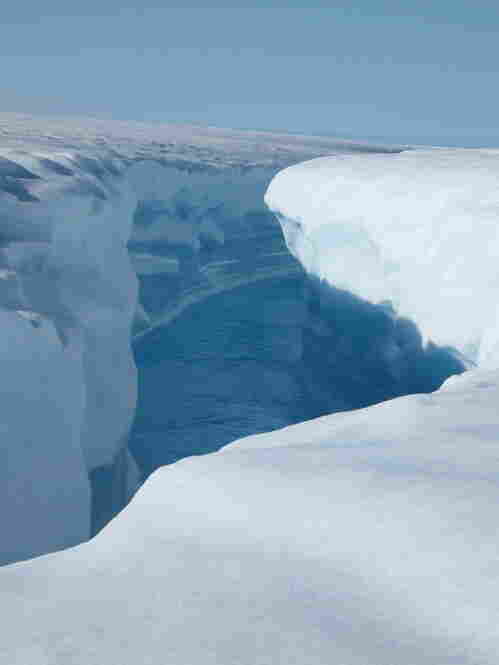 Rushing water at the end of a lake has cut a deep channel into the ice. Greenland's ice contains enough water to raise sea levels by 20 feet. 