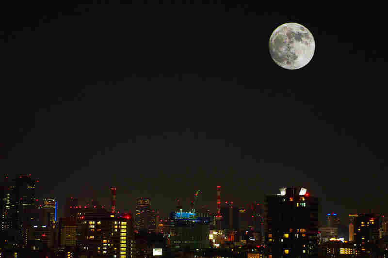 The moon shines bright over Tokyo, Japan. 
