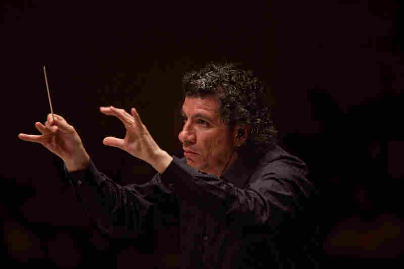 Like the other four conductors in Ives' massive symphony, music director Giancarlo Guerrero wears earbuds to hear the click track needed to keep all the musicians playing together.