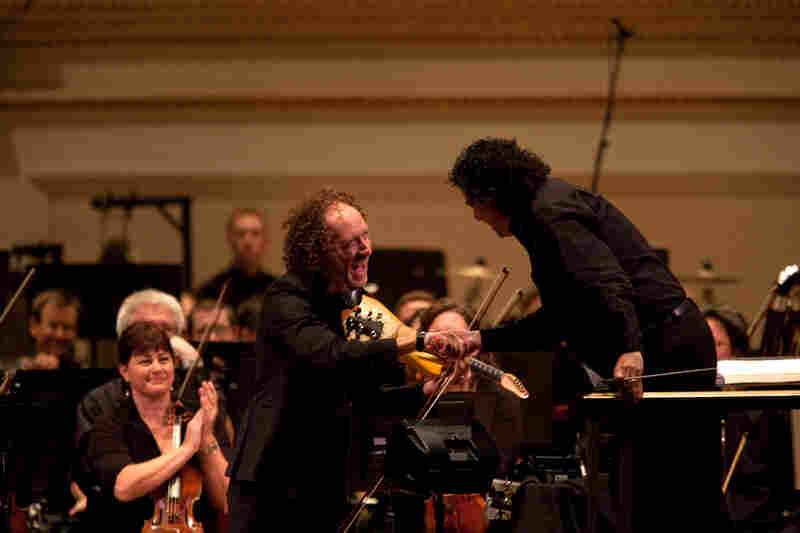 Tracy Silverman shakes hands with conductor Giancarlo Guerrero. Silverman says Riley's concerto is "a mashup of raga and ragtime." 