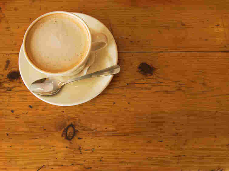 A cup of coffee on a wooden table.