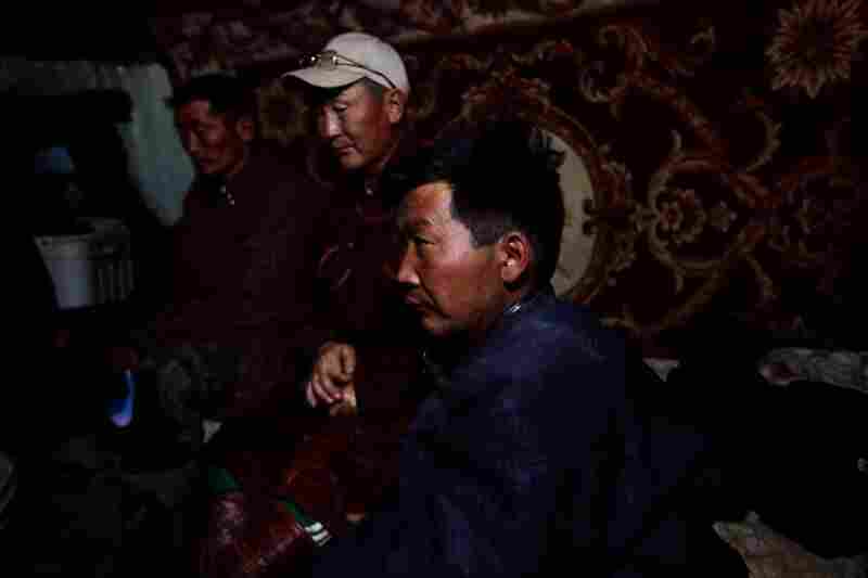 Ex-herders work at a makeshift truck stop for mining trucks. Most say their water supply dried up, leaving them no choice but to sell their animals.