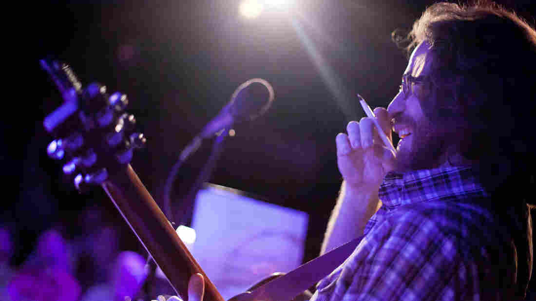 Ask Me Another's resident musician, the unstoppable Mr. Jonathan Coulton, pen in hand, works his improv magic on stage.