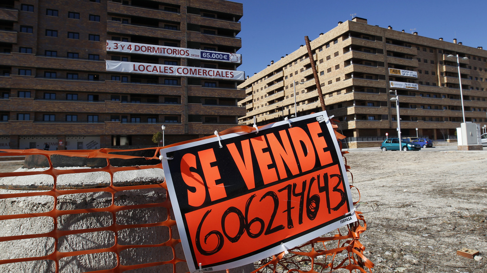 A "For Sale" sign hangs outside mostly empty apartment blocks in the Madrid satellite town of Sesena in February. Banks are trying to sell billions of euros worth of property left by bankrupt developers. This is attracting bargain-hunting investors from abroad. (Andrea Comas/Reuters/Landov)