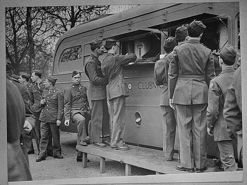 U.S. soldiers receive refreshments, including doughnuts, from an American Red Cross clubmobile in London. Soldiers today still resent a Red Cross move to charge for doughnuts. (Library of Congress)