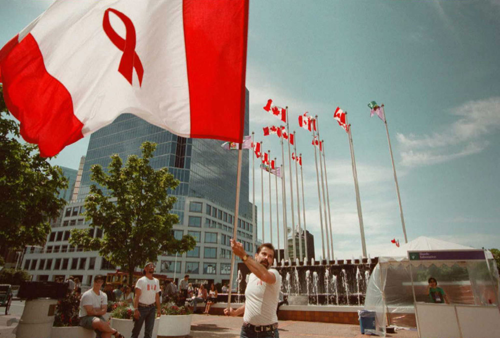 Kim Gerlach of Vancouver waves the flag designed by Affirmative Aids Action for the XI International Conference on AIDS, July 1996. (AFP/Getty Images)