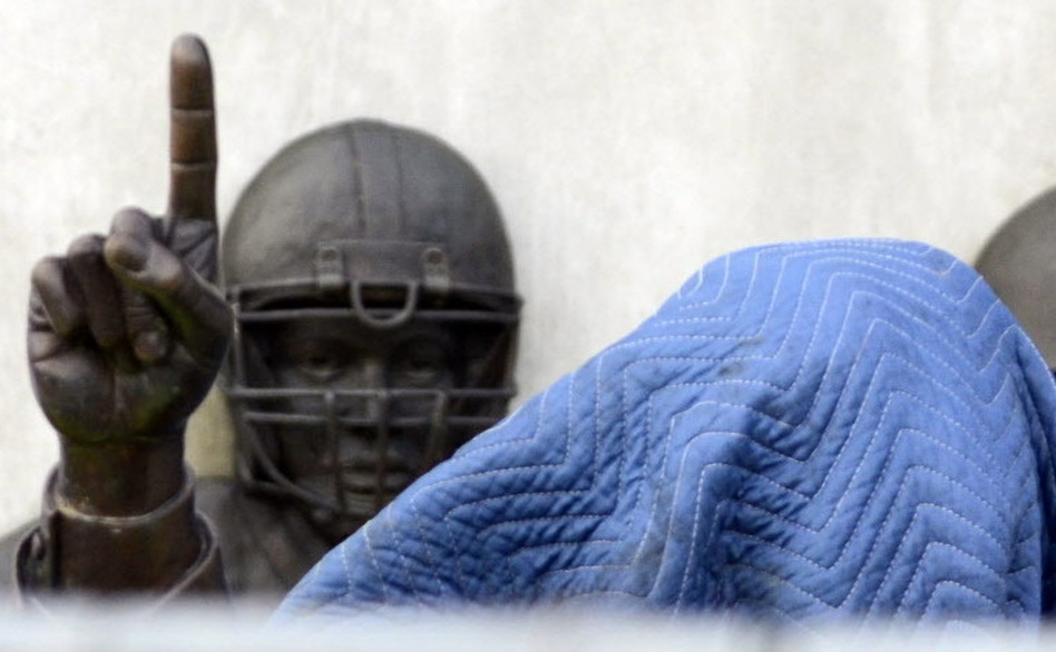 Before its removal from outside the school's football stadium on Sunday, a statue of former football coach Joe Paterno was covered. An independent report concluded he was among top university officials who failed to act when they learned that Jerry Sandusky might be sexually abusing young boys. (John Beale/AP)