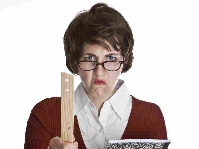 An angry teacher holding a composition book and pointing a ruler.